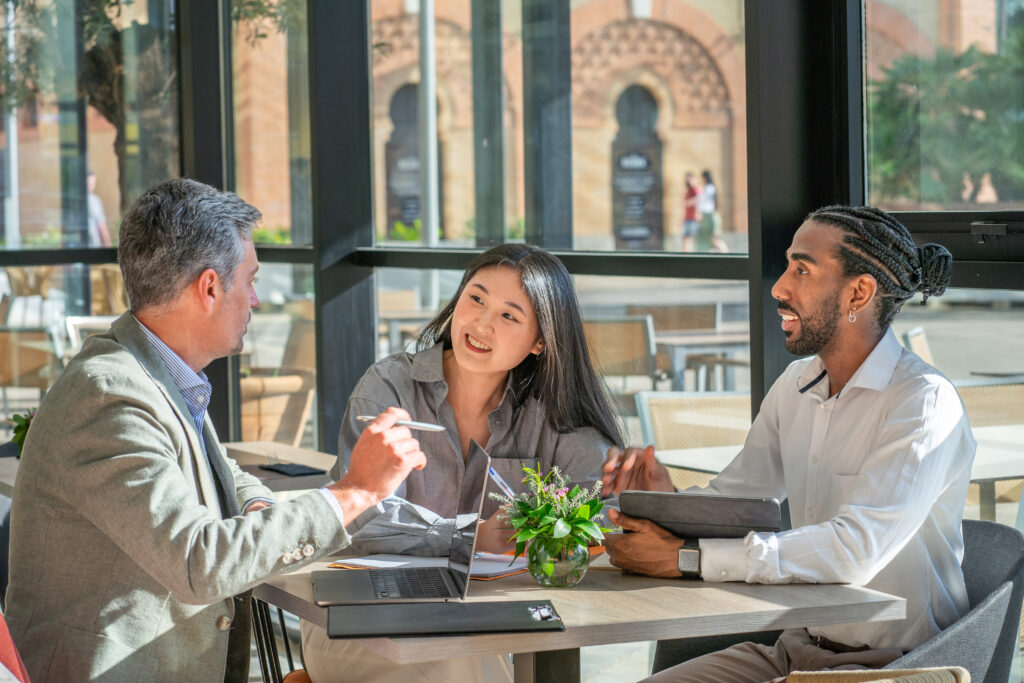 interracial businesspeople sharing a coffee together during a meeting inside the office